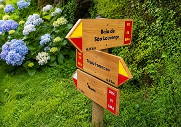 Wegweiser auf dem Wanderweg zur Baía de São Lourenço auf Santa Maria. Die Landschaft der Azoren ist geprägt von üppiger Vegetation, Hortensien und aussichtsreichen Küstenwanderungen.