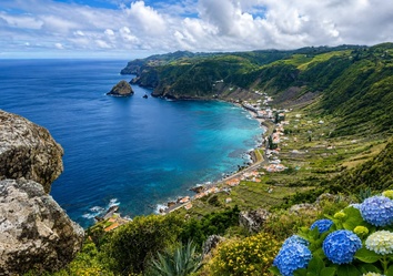Panoramablick auf die Baía de São Lourenço auf Santa Maria. Terrassenlandschaft, Atlantikküste, türkisfarbenes Meer und typische Hortensien prägen diese einzigartige Landschaft der Azoren.